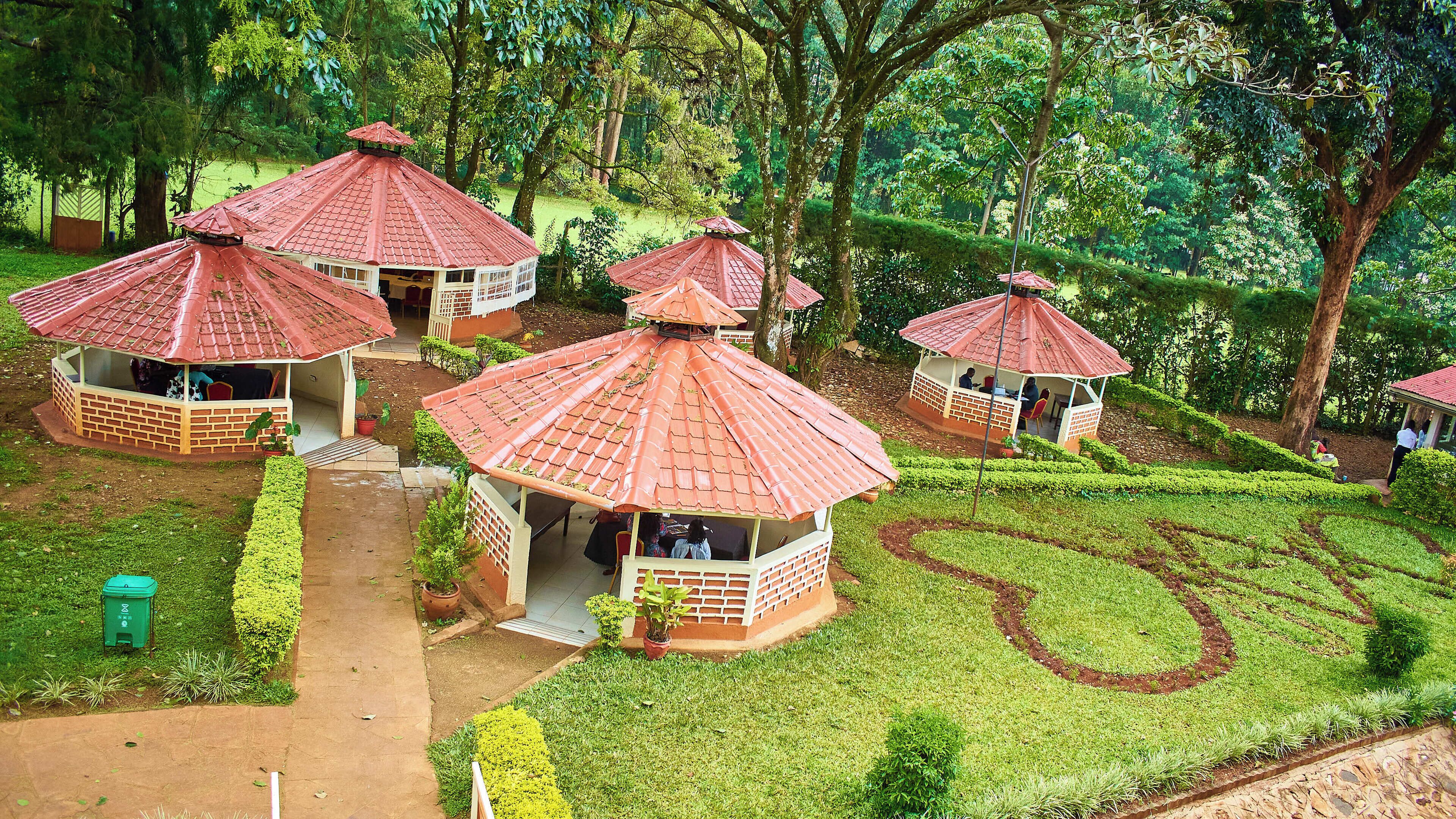 A gazebo-style structure with a tiled roof, surrounded by well-maintained grass and trees.
