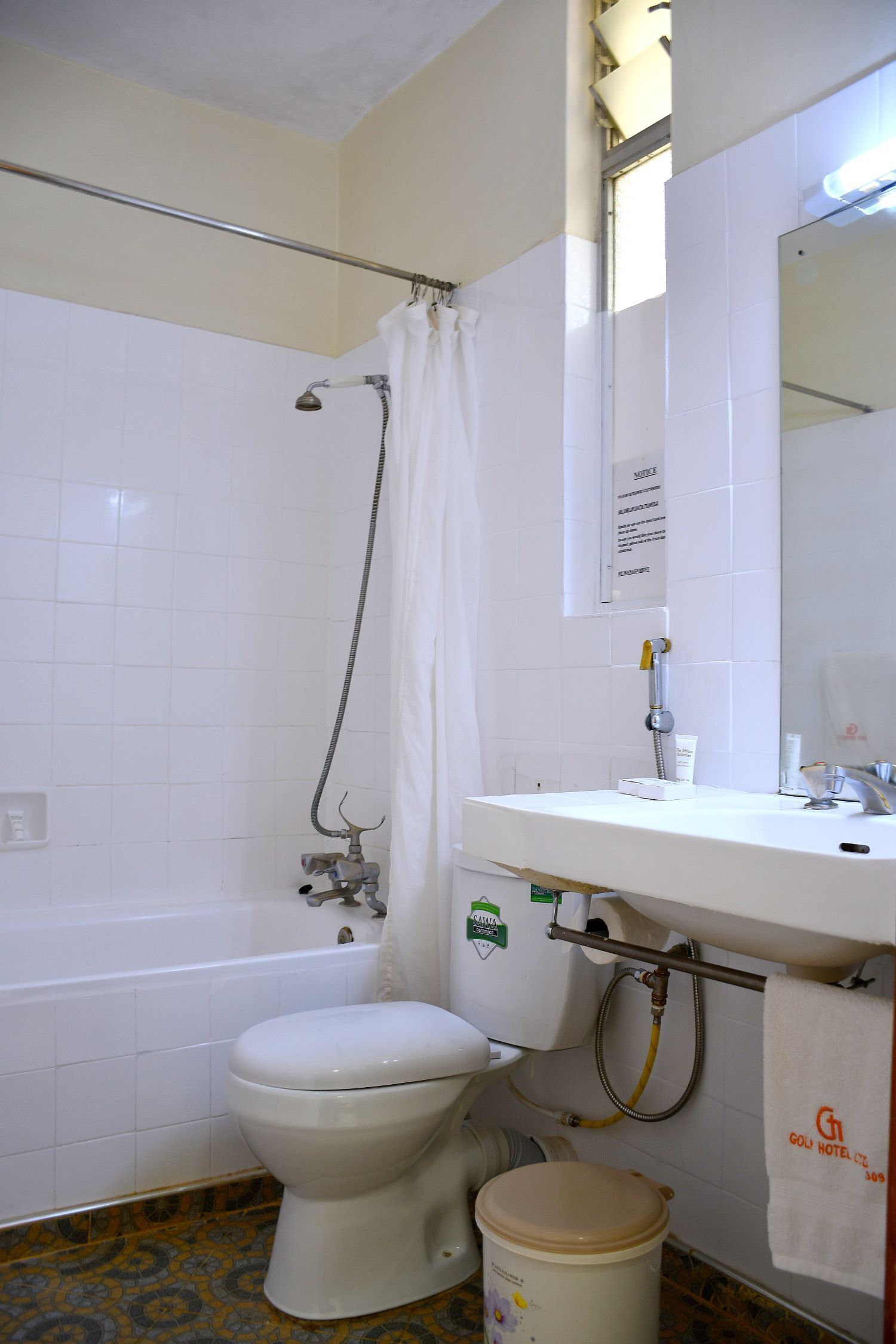 A bathroom with a toilet, a shower, and a sink.