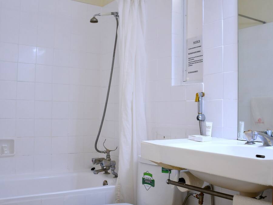A bathroom with a toilet, a shower, and a sink.