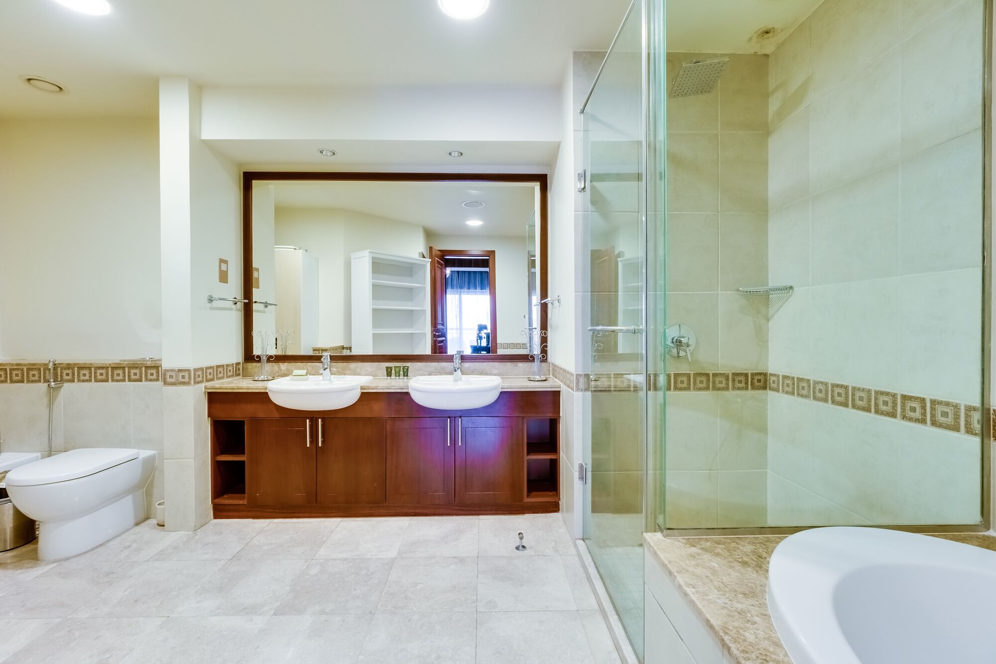 Une salle de bain moderne avec deux lavabos, une douche à l ’italienne et des toilettes.