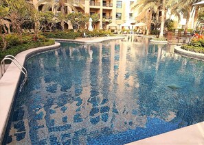 Utomhuspool, parasoller och solstolar