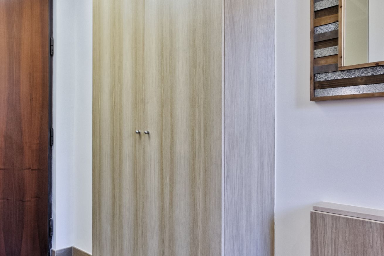 Ein Holzschrank mit einem Spiegel darüber.