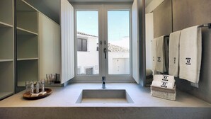 A modern bathroom with a large window, a sink, and a towel rack. - Alte Tradition Guest House (Loulé)