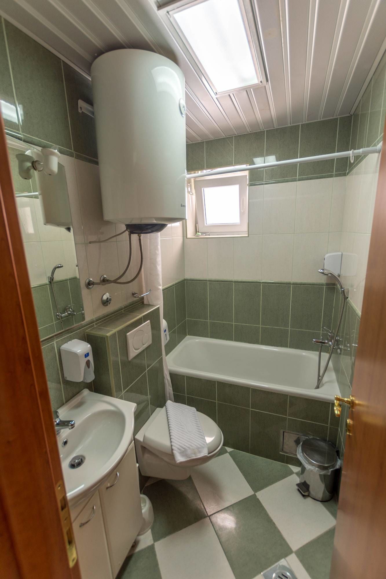 Une petite salle de bain comprenant des toilettes, un lavabo et une baignoire.