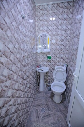 Standaard vierpersoonskamer, balkon | Badkamer | Een douche, een haardroger, pantoffels, toiletpapier