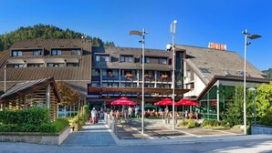 A hotel with a modern design, outdoor seating area, and a visible sign indicating it is a hotel. - Hotel Cerkno (Cerkno)