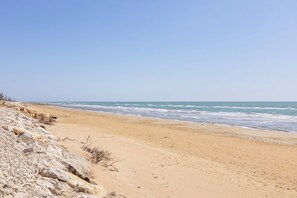 A beach with rocky terrain and a sandy shore. - GuestHost - Cosy 100 sqm apartment, organized on two levels (ground and first floor), perfect for 5 people located 500m far from the sea and the beautiful beaches, has a large balcony with outdoor table, perfect for lunch and breakfast outside enjoying t (Santa Maria del Focallo)