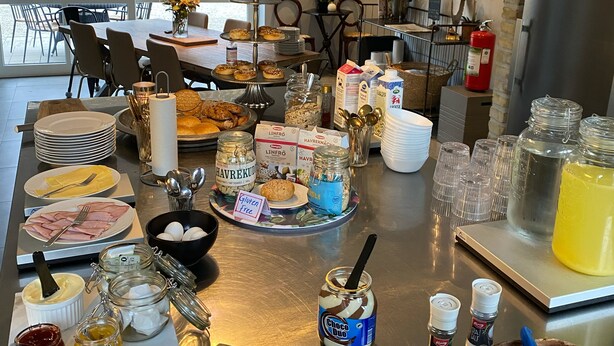Un bufé de desayuno con diversos alimentos, como frutas, pastelería y salsas.
