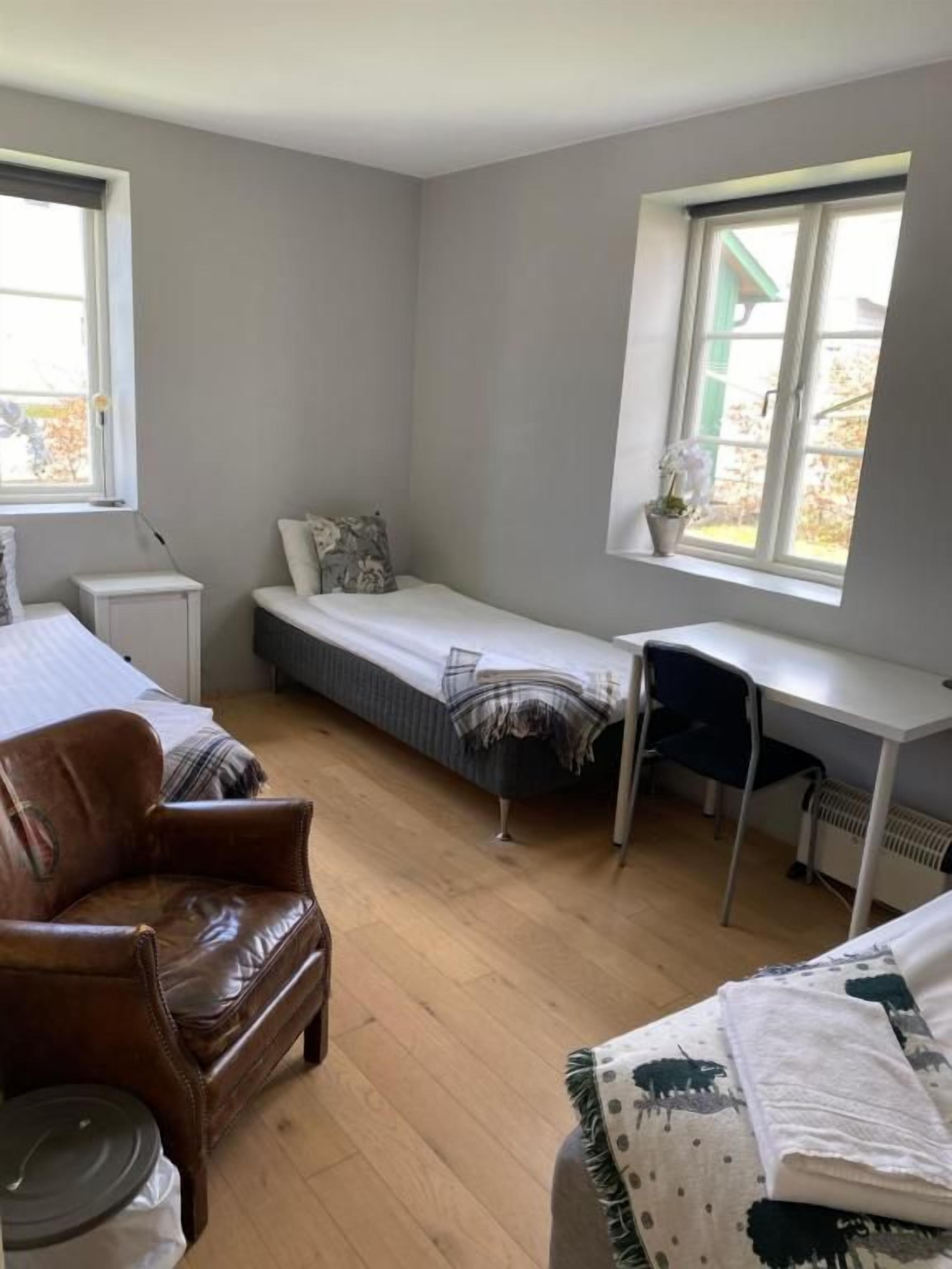 A room with a bed, a desk, a chair, and a window.