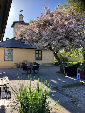 A building with a patio area, outdoor seating, and a parking sign. - Brohuspark (Lomma)