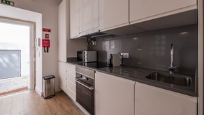 A modern kitchen with stainless steel appliances, a black countertop, and a stainless steel sink. - Soul House - Exclusive Apartment - Your Home away from Home (Lisboa)