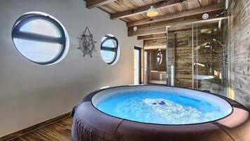 Relax in a spacious bathroom with a large hot tub and glass shower enclosure.