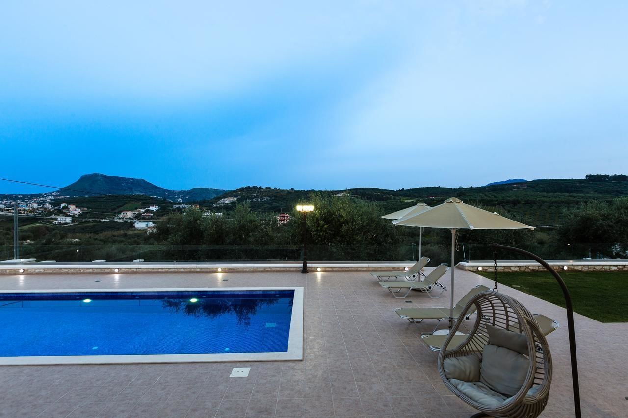 A swimming pool with a view of hills and a city in the background.