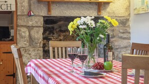 A dining table with a checkered tablecloth, a vase with flowers, wine glasses, and a bottle of wine. - 3 bedroom accommodation in Nanpean, near St Austell (Nanpean, near St Austell)