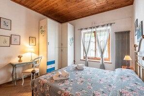 A bedroom with a bed, a desk, a chair, and a wardrobe. - old barn on Via Francigena (Siena)