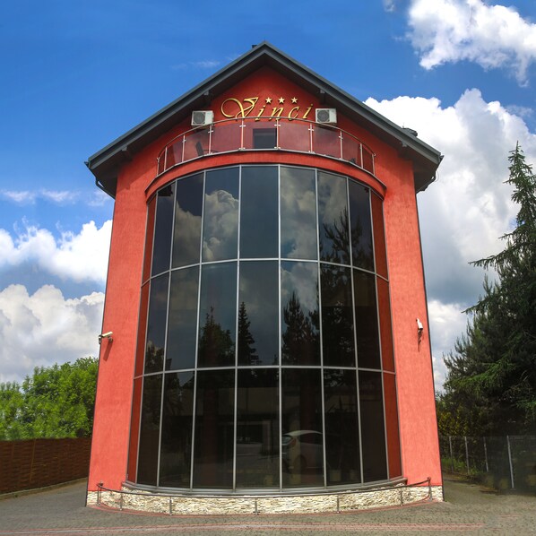 A red building with a large glass facade and a sign that reads "Zinci".