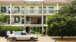 Un edificio de varios pisos con balcones y un coche estacionado en la parte delantera.