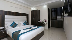 A modern hotel room with a large bed, a desk, and a television. - Hotel Capital Mount (New Delhi)