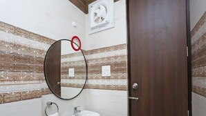 A bathroom with a white sink, a mirror, and a towel rack. - Hotel Capital Mount (New Delhi)