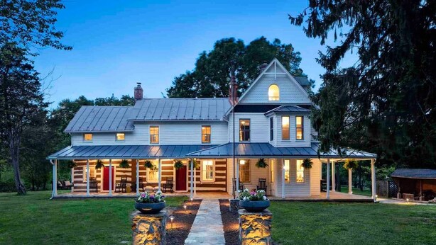 A two-story house with a covered porch, a stone pathway, and a well-maintained lawn. - 1805 Farmhouse with Heated Pool in Harpers Ferry (Harpers Ferry)