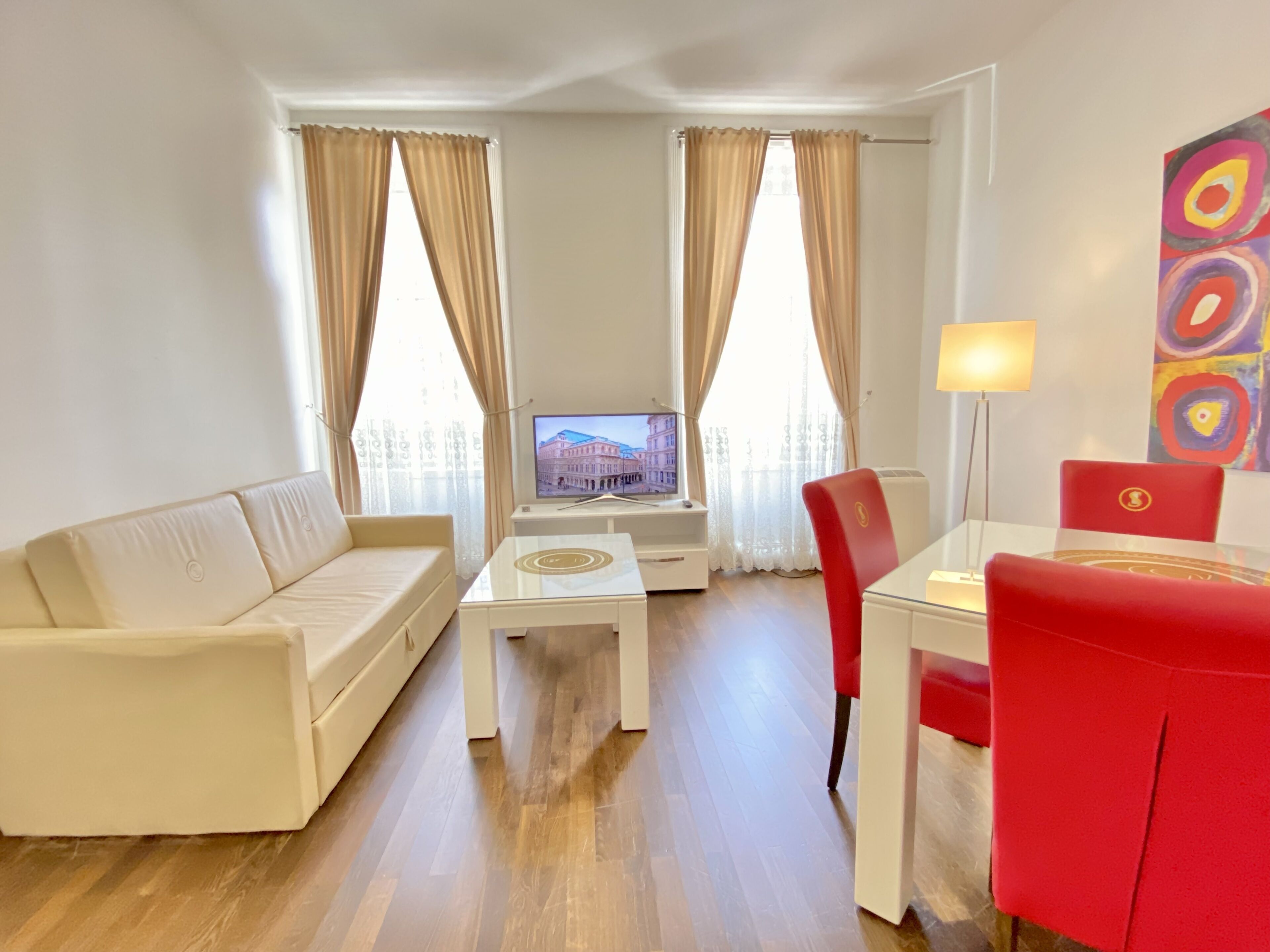 Un salon moderne comprenant un canapé, une table basse, un téléviseur et un coin repas avec une chaise et une table.