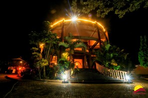 A building with a circular structure, a staircase leading to the entrance, and a well-lit entrance area. - Shine Resort Hotel (Kampala)