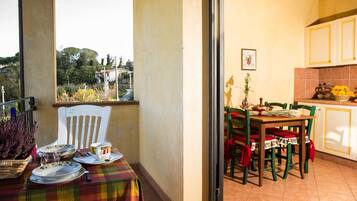 Ein Balkon mit Tisch für zwei Personen, einem Stuhl und Blick ins Freie.