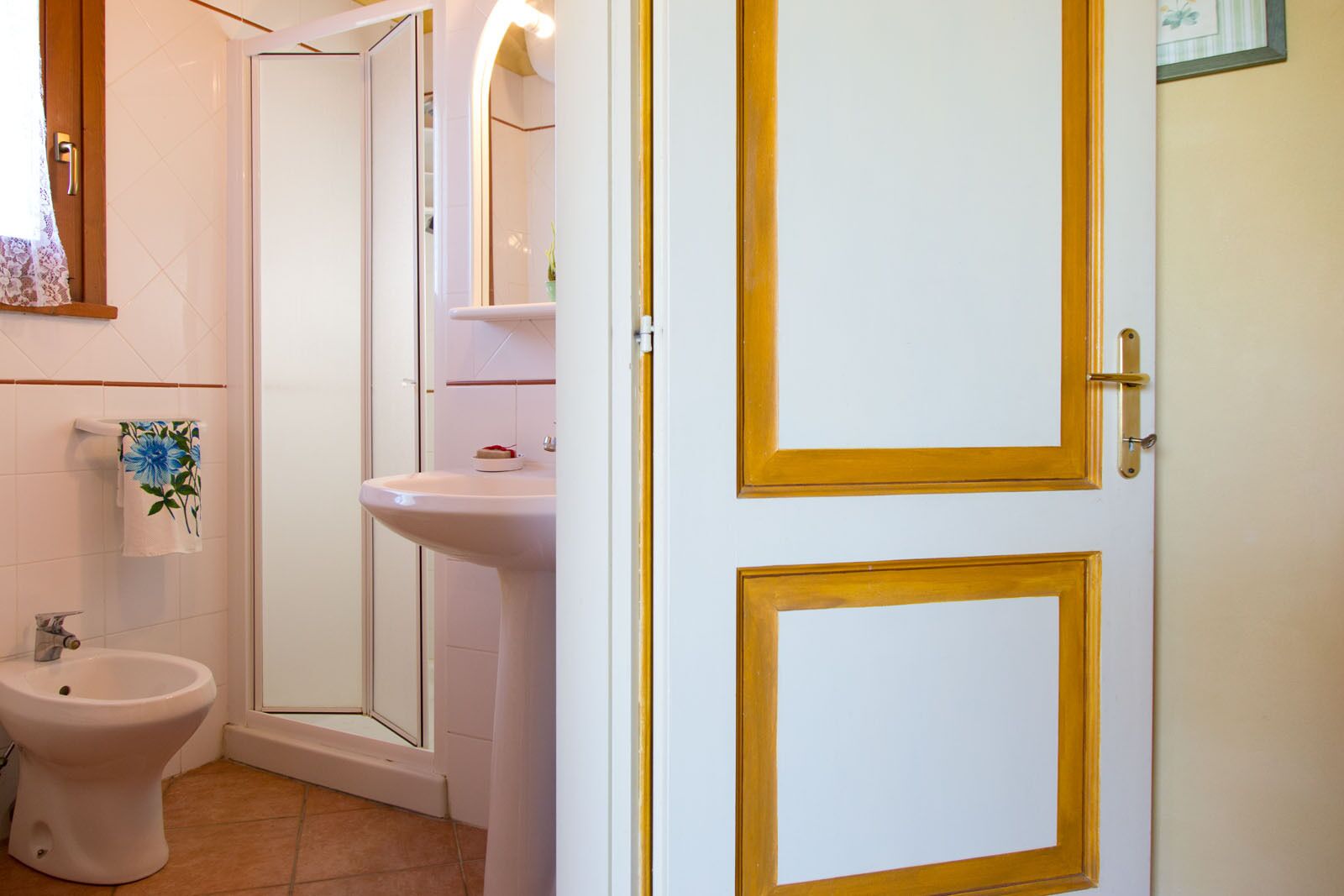 A bathroom with a toilet, bidet, sink, and mirror.