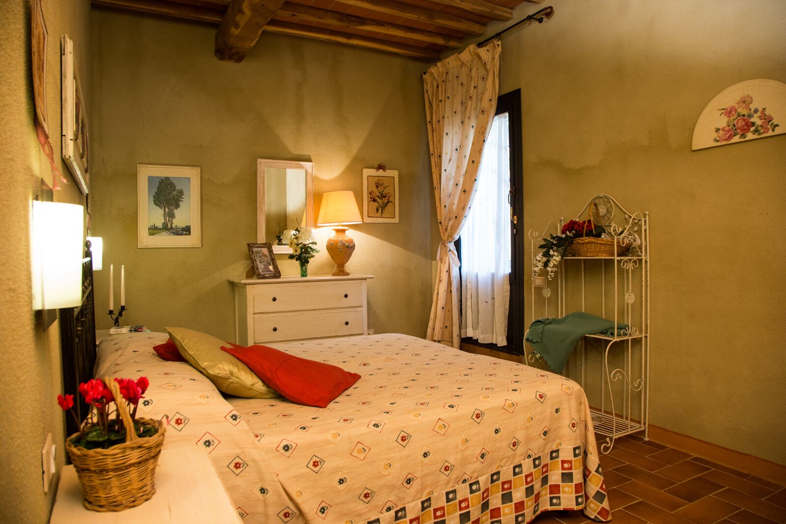 Quarto com cama, penteadeira, luminária, espelho e janela com cortinas.