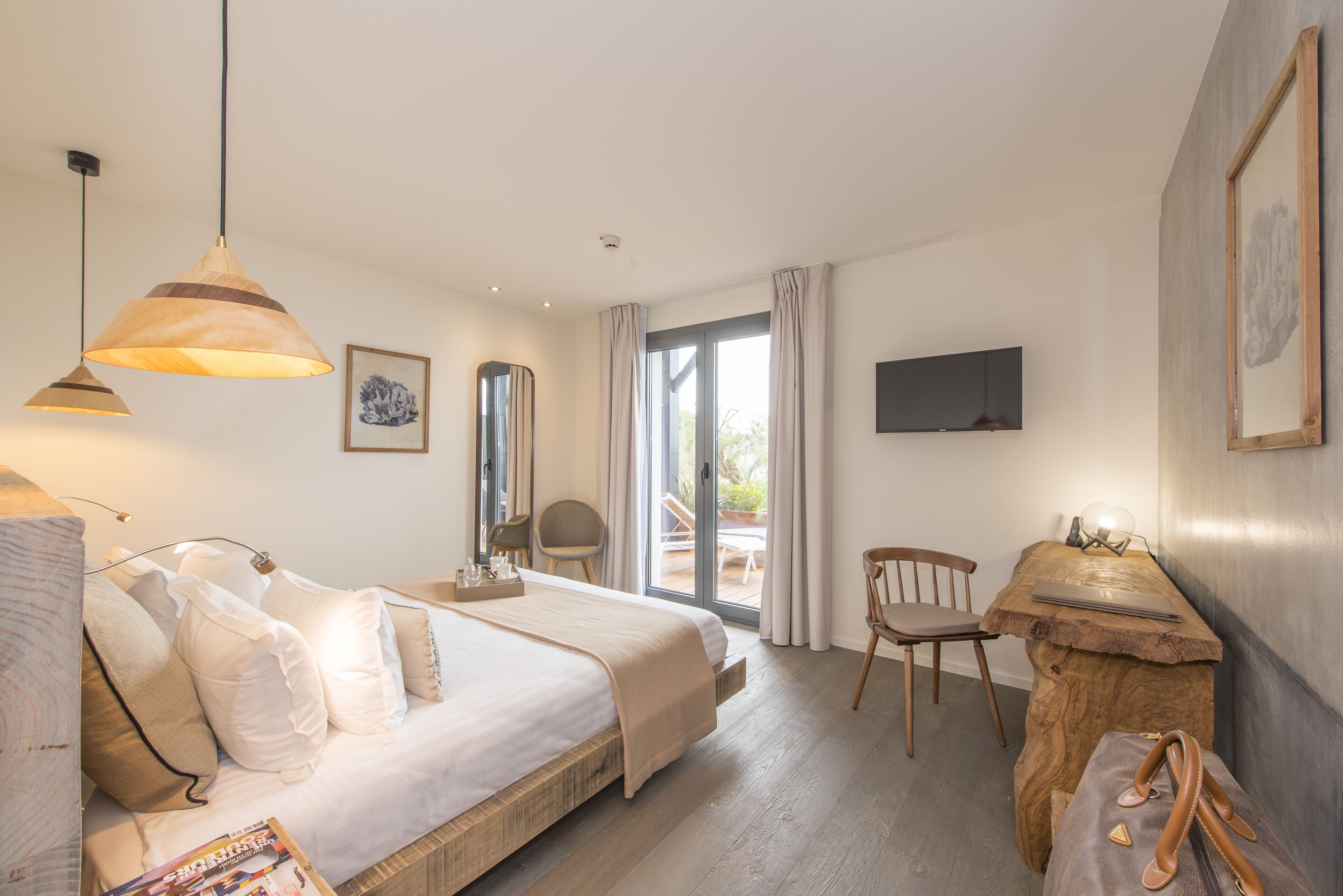 Une chambre d’hôtel équipée d’un lit, d’un bureau, d’une chaise, d’une télévision et offrant une vue sur l’extérieur.
