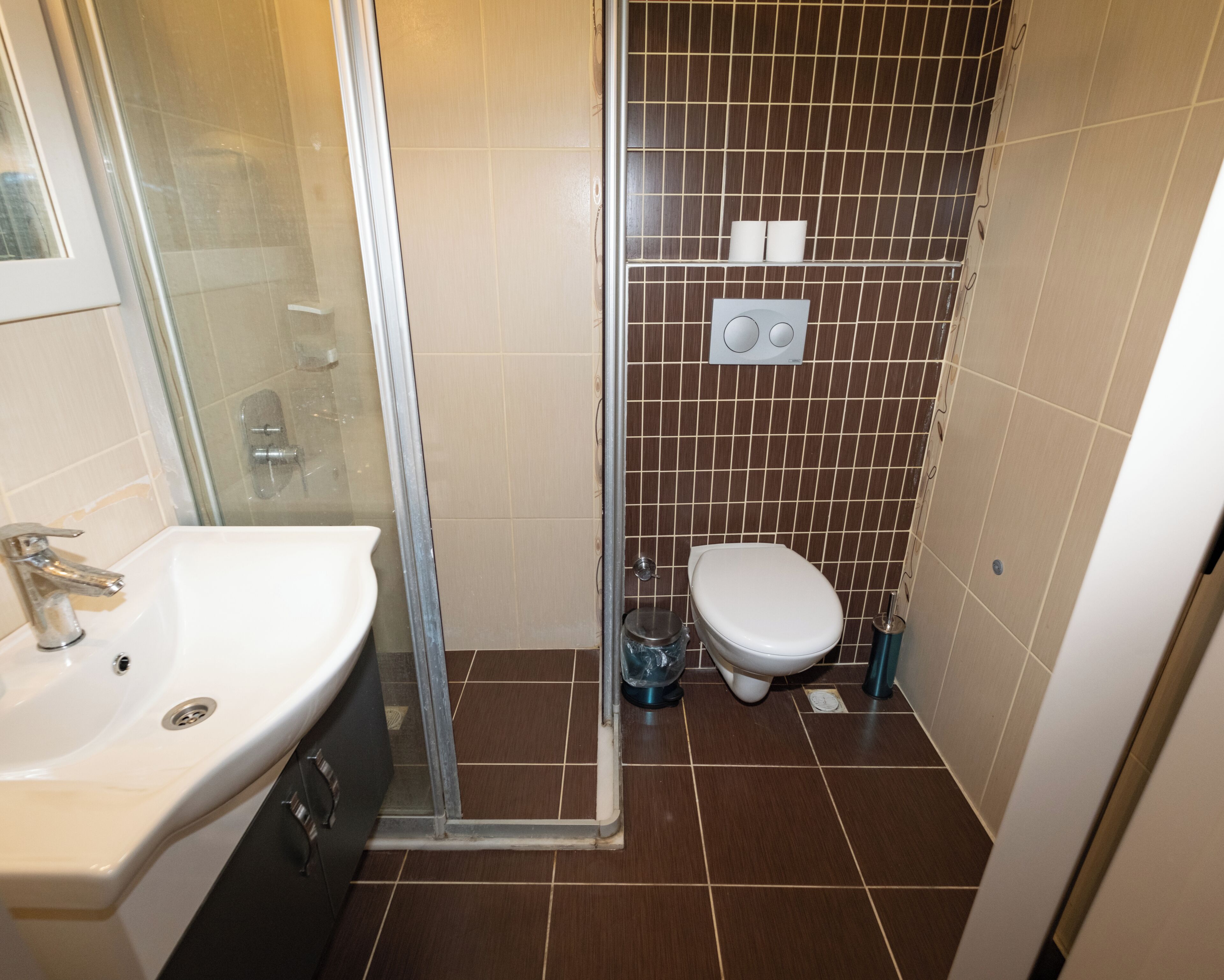A bathroom with a shower, toilet, and sink.