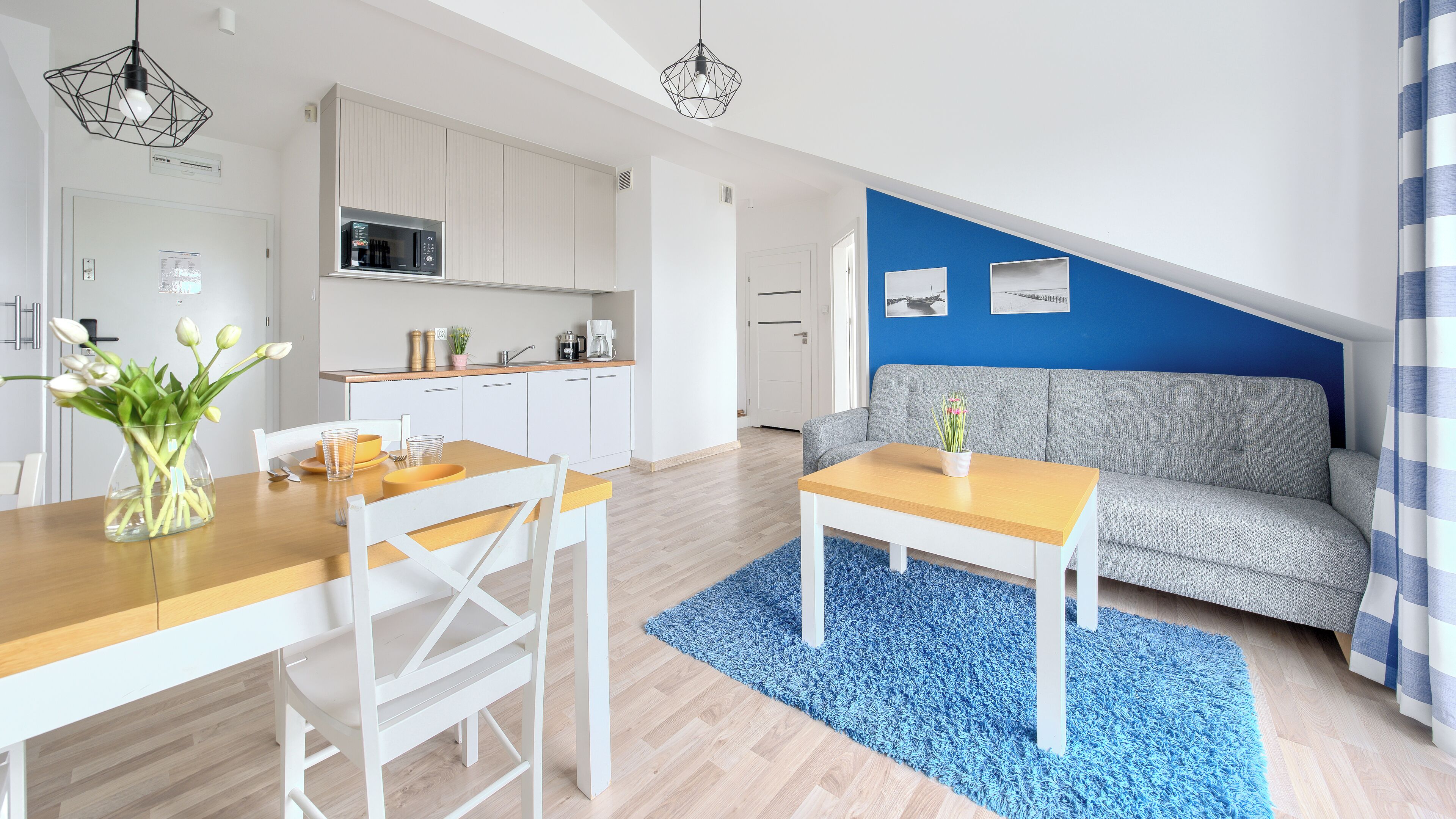 A modern apartment with a kitchen, dining area, and living room.