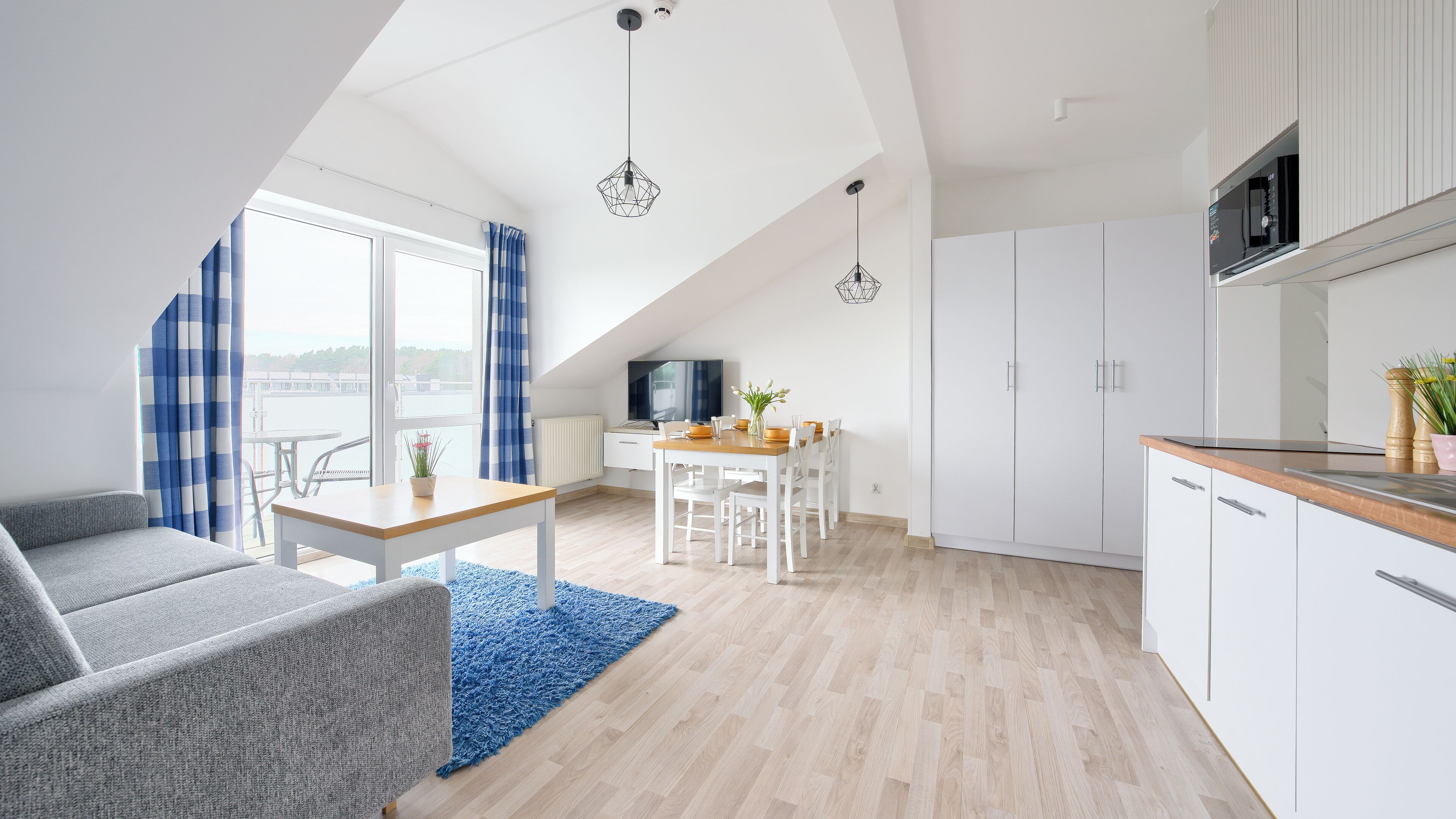 Un appartement moderne doté d’un coin repas, d’une cuisine et offrant une vue sur la mer.