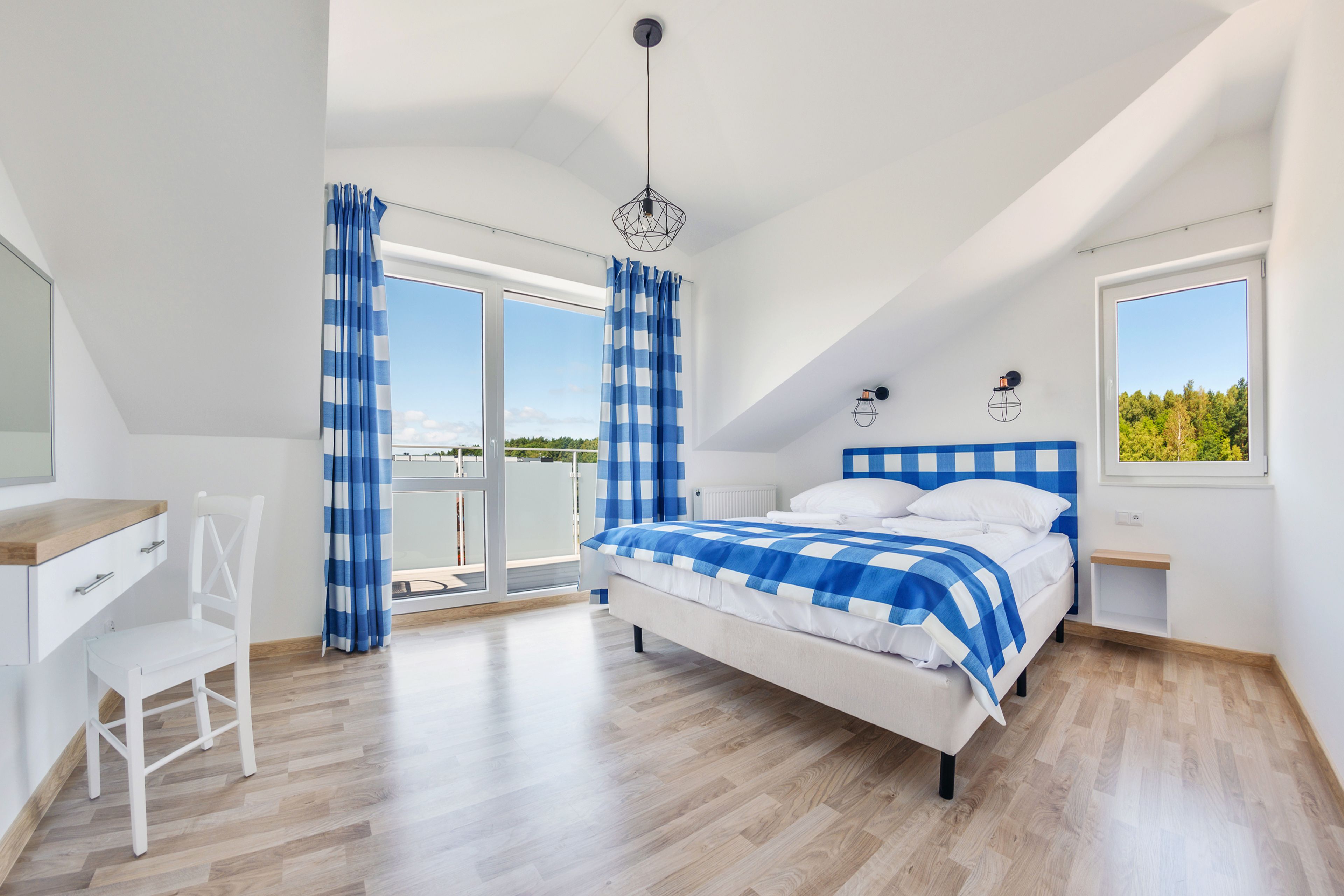 A bedroom with a bed, a desk, and a chair.