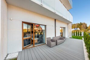 A modern house with a deck, sliding glass doors, and outdoor furniture. - Sun & Snow Seaside Grzybowo (Kolobrzeg)