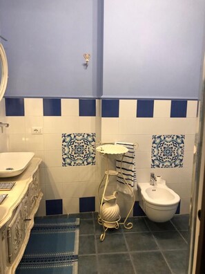 A bathroom with a sink, bidet, and decorative towel rack. - Le Stanze del Borgo (Nettuno)