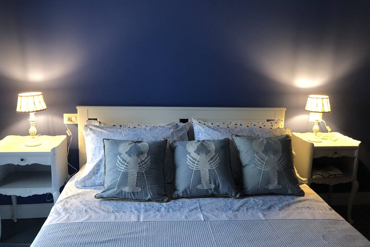 A bedroom with a bed, two bedside tables, and two lamps.