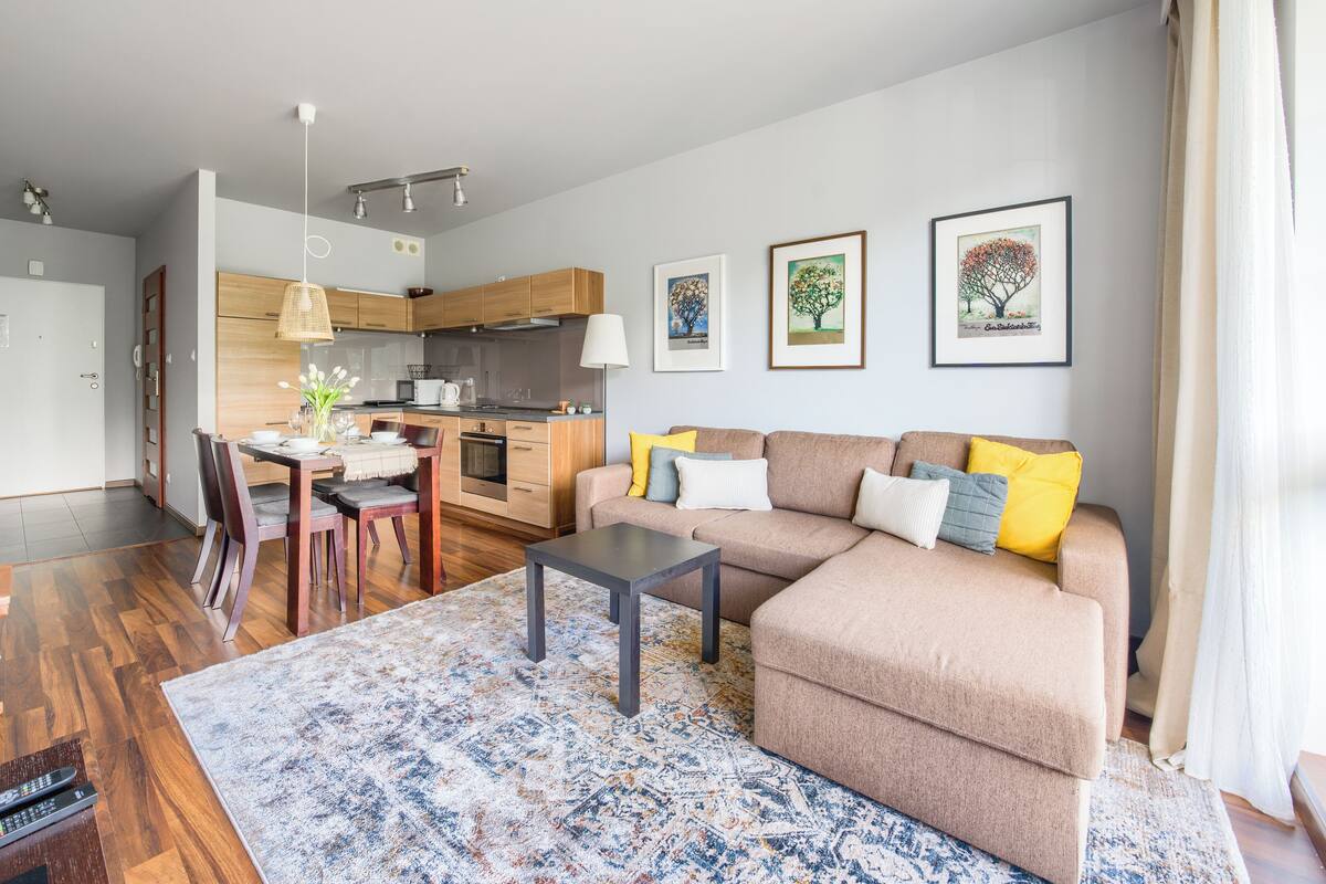 Una sala de estar moderna con sofá, mesa de centro y comedor.
