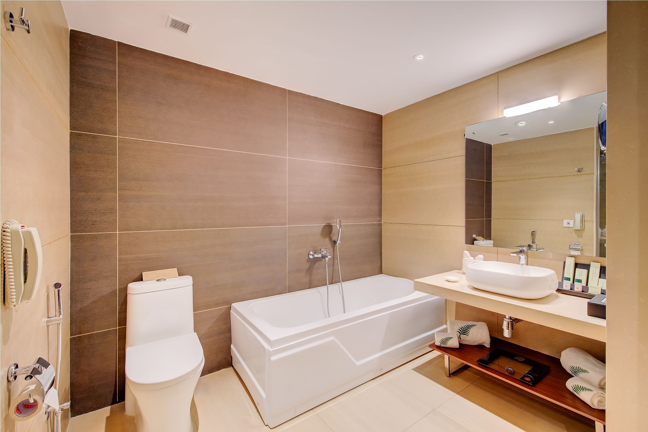 A modern bathroom with a bathtub, toilet, and vanity.