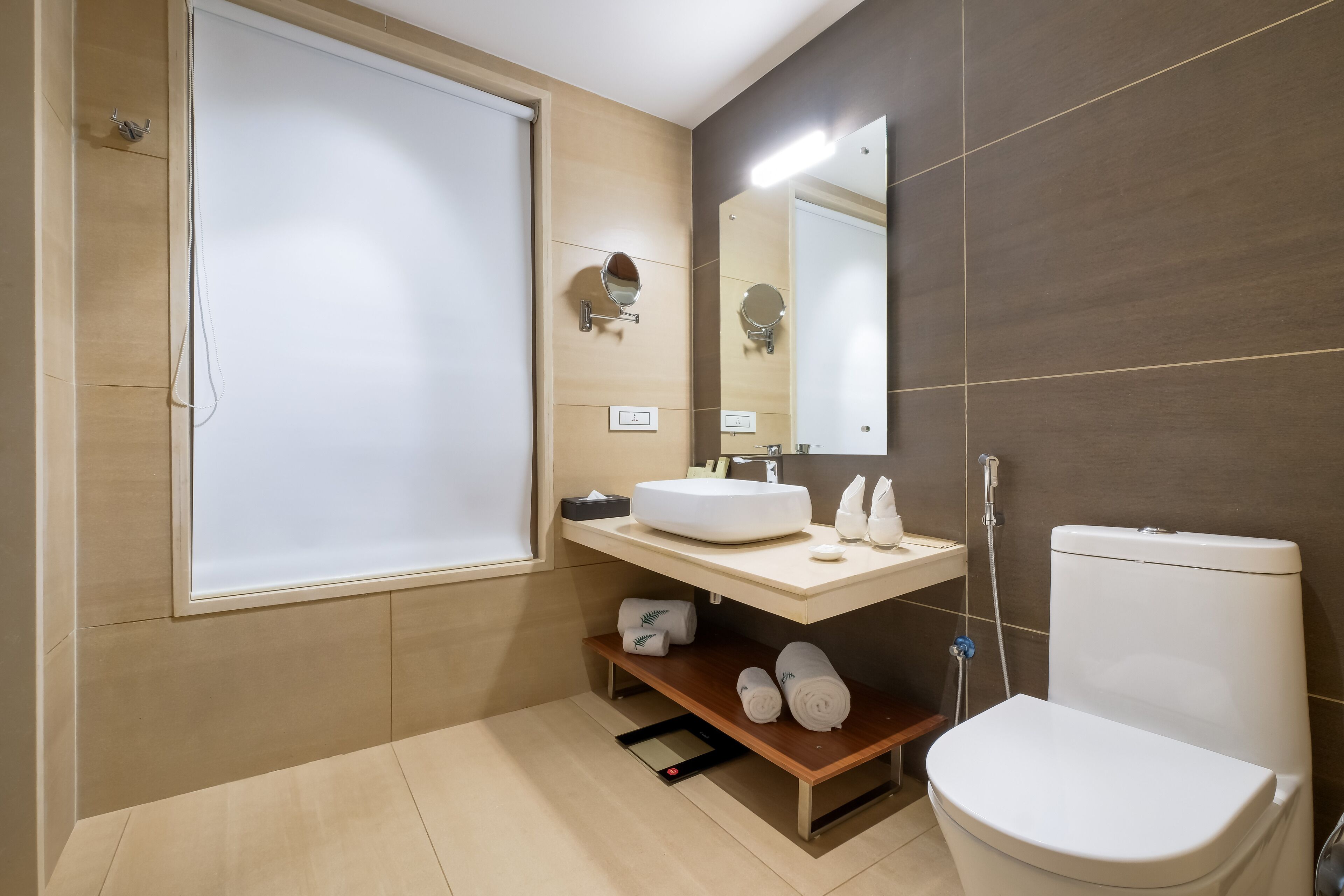 Un baño moderno con inodoro, lavamanos y espejo.