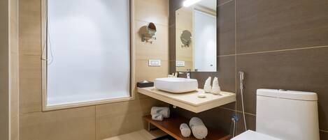 Un baño moderno con inodoro, lavamanos y espejo.