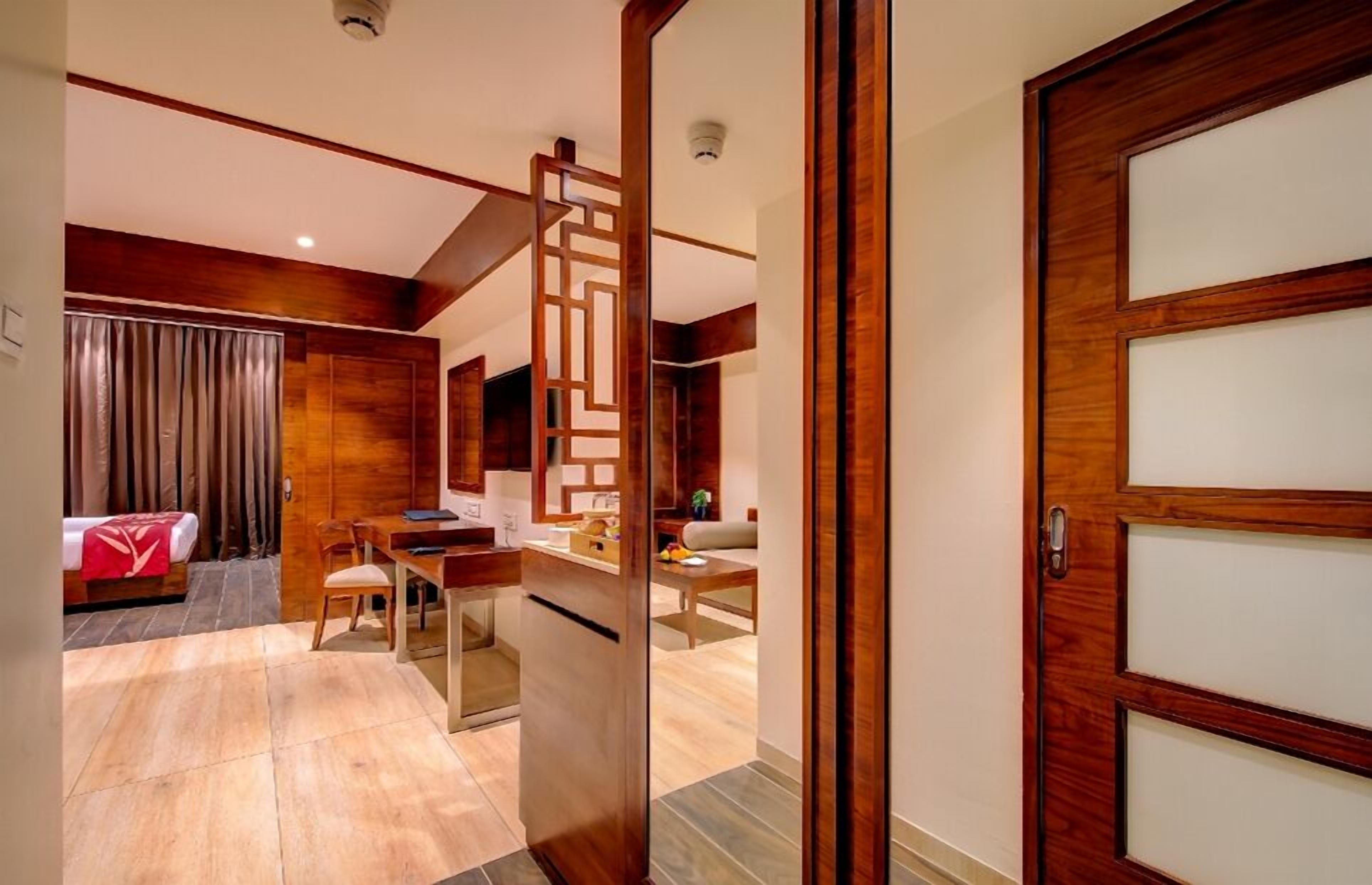 A hotel room with a wooden interior, a dining area, and a separate living space.