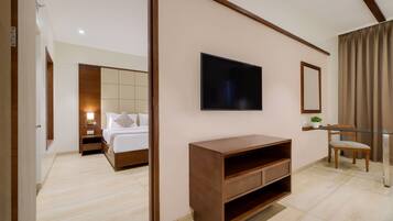 A modern hotel room with a bed, a TV mounted on the wall, a wooden console table, and a chair.