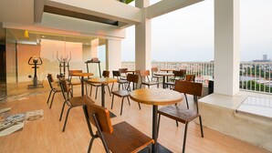 A modern interior with high ceilings, large windows, and a view of the cityscape. - Life Style Surabaya (Surabaya)