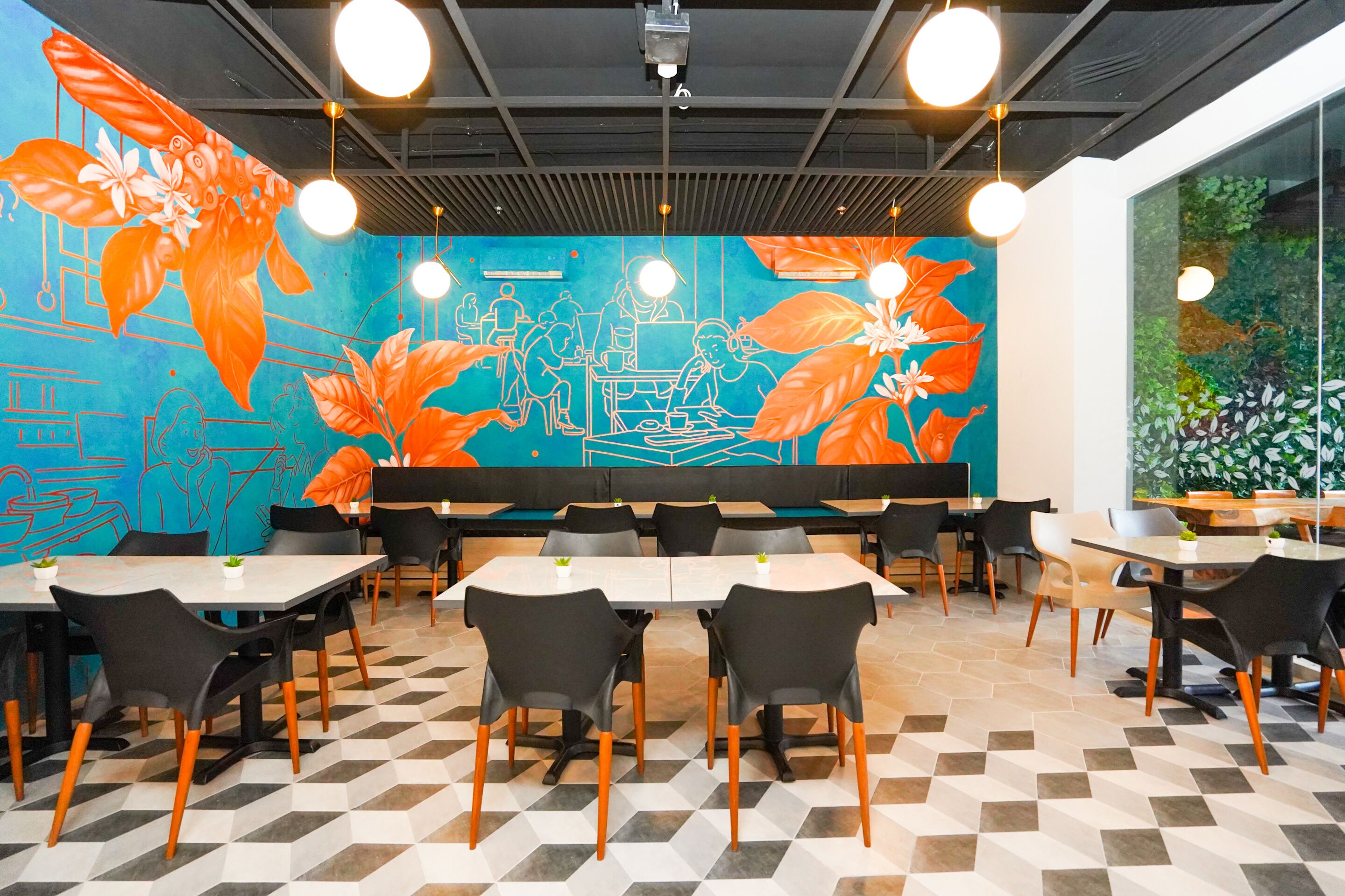 A modern restaurant with a geometric floor pattern, black and white chairs, and a mural with orange leaves and blue background.