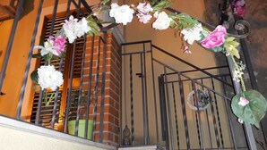 A staircase with a metal railing and a floral decoration. - B&b Il Cortile (Mazzarino)