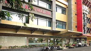 En byggnad med en skylt där det står ”Hotel Malaya”, och ett antal motorcyklar parkerade framför.