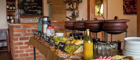 Un buffet proposant divers plats, une machine à café et un menu écrit à la craie dans un restaurant.