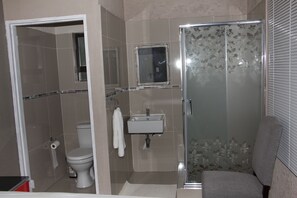 A bathroom with a toilet, sink, and shower.