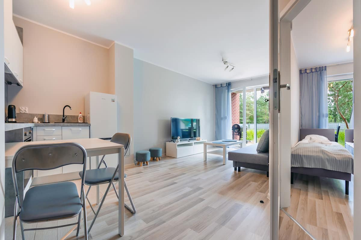 A modern apartment with a kitchen, dining area, living room, and a bedroom.